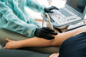 Doctor performing ultrasound scan on patient's arm