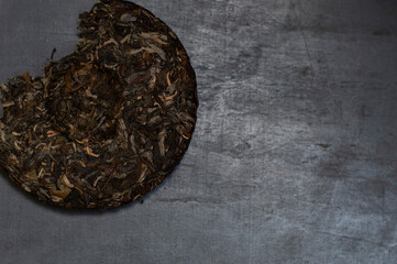 Pressed broken pancake shape sheng puerh on a black background