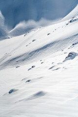 Pristine Snowy Slope with Rocks and Shadows
