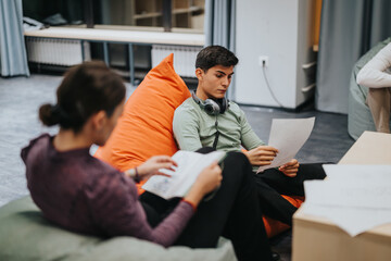 Two students study in a comfortable and modern classroom setting, highlighting a relaxed and engaging learning atmosphere.