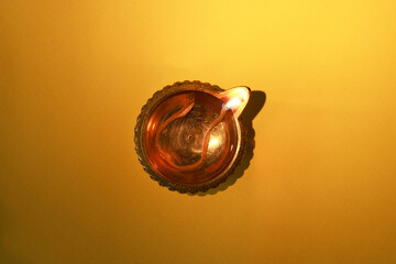 Diwali celebration. Diya lamp on orange background, top view