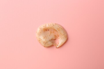 Smear of body scrub on light pink background, top view