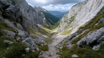 Obraz premium breathtaking view of rocky valley surrounded by steep mountains, showcasing natural beauty of landscape. sunlight casts dramatic shadows, enhancing rugged terrain