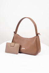 Women's brown handbag and wallet isolated on white background