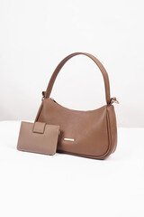 Women's brown handbag and wallet isolated on white background