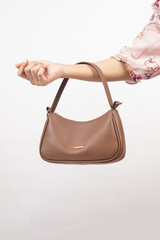 Women's luxury handbag in girl's hand, brown handbag purse, leather bag isolated on white background