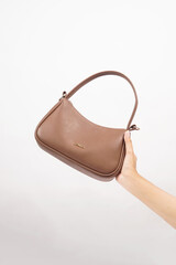 Women's luxury handbag in girl's hand, brown handbag purse, leather bag isolated on white background