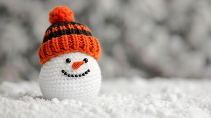 Obraz premium Crochet snowman with a festive hat on snow.