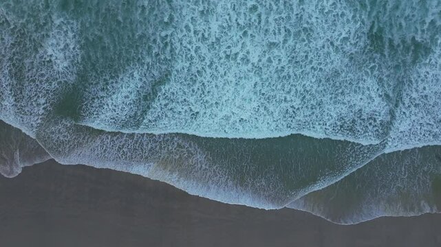 Aerial footage of the Atlantic Ocean waves on the sandy shore of Caion city, A Coruna, Spain