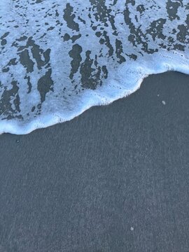 Ocean Wave Sea Foam in the Sand