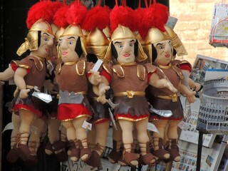 Linw of Roman soldier dolls with red plumes on their helmets arranged in a neat row - Powered by Adobe