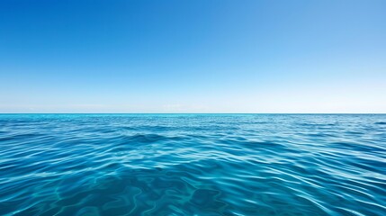 Obraz premium A serene view of the calm ocean, with clear blue waters meeting a bright sky.