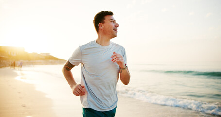 Fitness, man and running on beach for exercise, wellness and endurance training at space. Runner, cardio and happy athlete at ocean with energy, physical health and resilience at California seaside © peopleimages.com