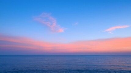 Fototapeta premium Peaceful ocean horizon at sunset with soft pink and blue clouds. A serene and minimalistic seascape perfect for backgrounds, meditation, travel, and nature concepts