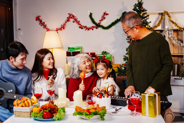 Parents, children, and grandparents gather at home for a joyful Christmas and New Year celebration, also marking the granddaughter’s birthday. They share wine, food, drinks, and exchange gift boxes