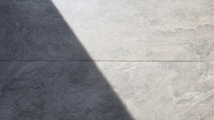Fototapeta premium light and shadow on a grey concrete floor. Shadows of building pillars on the gray walkway. Afternoon sunlight shines down on the ground.