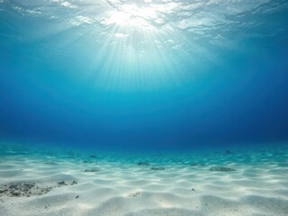 Fototapeta premium Underwater background with deep blue sea and beautiful light rays shining down on sandy ocean floor, light rays