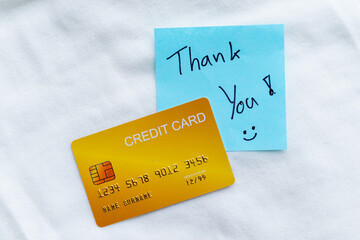 Thank you note with credit card business transaction personal finance indoor setting close-up view...