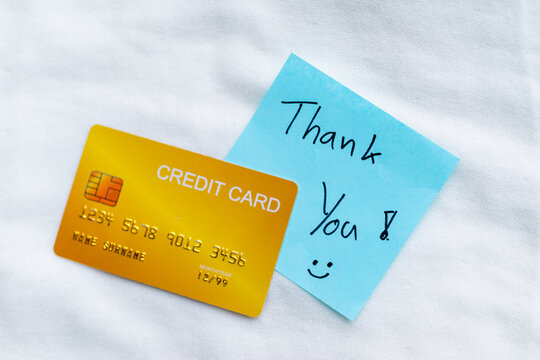 Business transaction process featuring credit card and thank you note home office setting digital content productive environment close-up viewpoint