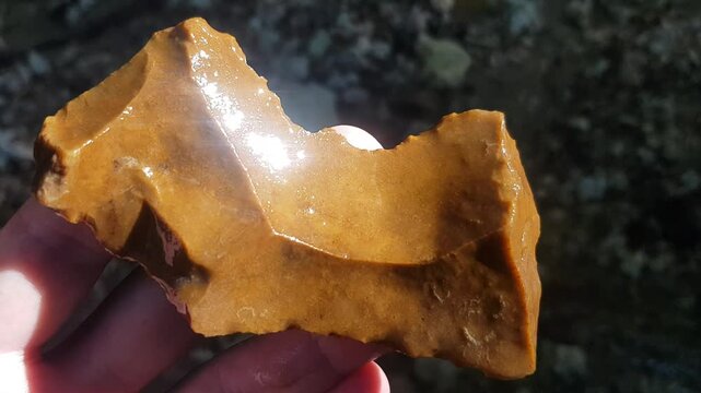 Flint scraper found in water, inspection at the site of discovery, Stone Age tool. Russia
