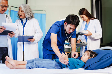 Obraz premium A doctor listens to a little girl’s heartbeat with a stethoscope while she lies on a bed in the hospital. The doctor is conducting a routine checkup to monitor her health