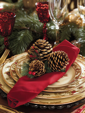 christmas table setting, tables etting with pinecones, red napkins and gold porcelain plates, Christmas still life, Holiday decor, Xmas, December dinner