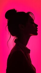 Fototapeta premium Profile silhouette of a woman with tied hair, set against a vivid pink backdrop for a dramatic effect.