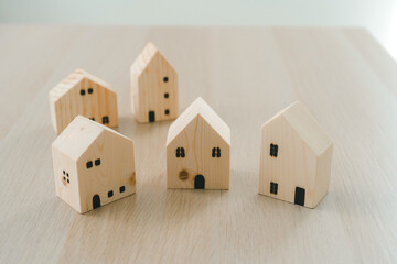 Minimalist Wooden House Models Arranged on Wooden Surface. Real Estate, Housing, Business and Property Investment Concepts in Simple and Elegant Style.