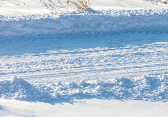 A snow covered road with tire tracks