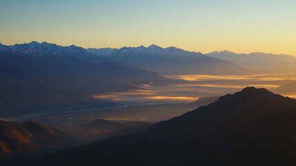 Obraz premium Golden Sunrise Over Mountain Peaks