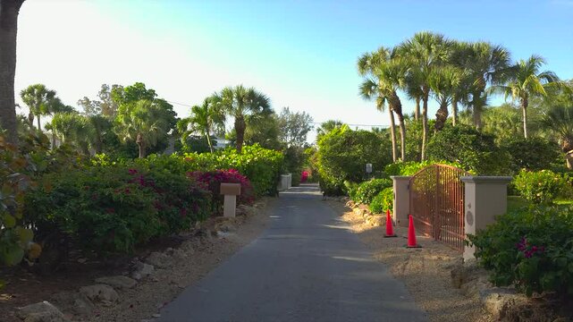 Driving on scenic road in sunny Florida. Casey Key coastal residential community picturesque streets.