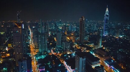 Obraz premium Night view of Bangkok's Sathorn area with brightly lit skyscrapers and busy streets below