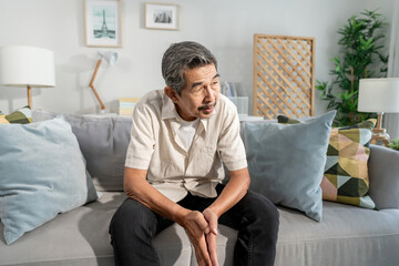 Asian senior elderly depress man sitting alone in living room at home.