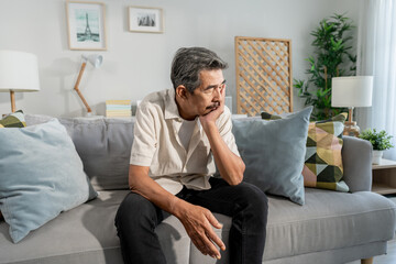 Asian senior elderly depress man sitting alone in living room at home. 