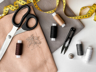 Sewing essentials with scissors, measuring tape, and thread on fabric