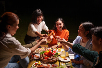 Group of young Asian friends enjoying dinner party together Barbecue grilling, drinking beer, people, food, healthy fruits and vegetables, celebrating, lifestyle drinks. New Year celebration concept.