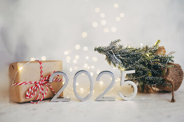 New Year's lights gold and dark red colors bokeh background with glowing number 2025 and fireworks. Happy New Year concept for 2025.