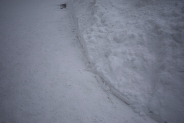 Cleared snow. A lot of snow on the road. A snowdrift on the street.
