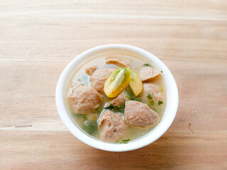 meatball soup served in a white bowl on a wooden background. bowl with yummy meatball soup. warm and delicious food