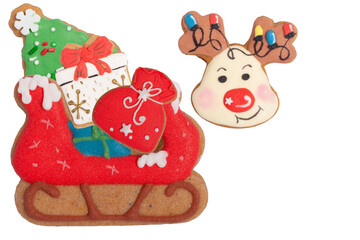 Naklejka premium Composition with reindeer and sleigh with gifts made of homemade gingerbread cookies isolated on white, isolated Christmas composition of cookies on white background, flat lay, top view, copy space