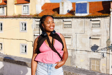 Black African woman with headphones on the rooftop

