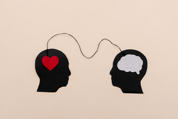 Silhouettes of two black human heads connected by a string symbolizing emotional intelligence and...