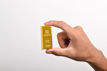Hand holding gold bars on white background, closeup