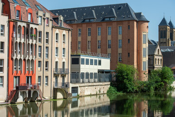 Naklejka premium vue du centre ville de Metz, au bord de la Moselle à proximité du petit port de plaisance reflet des bâtiment dans l'eau