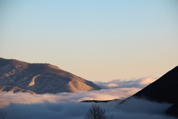 Obraz premium sunset over the mountains, Mountains in fog, mountain valley in fog and clouds, Low clouds, Foggy morning in the mountains