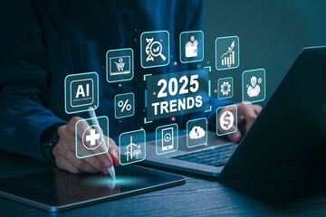 2025 Trends concept. A businessman working on laptop with 2025 TRENDS globe and icons representing...