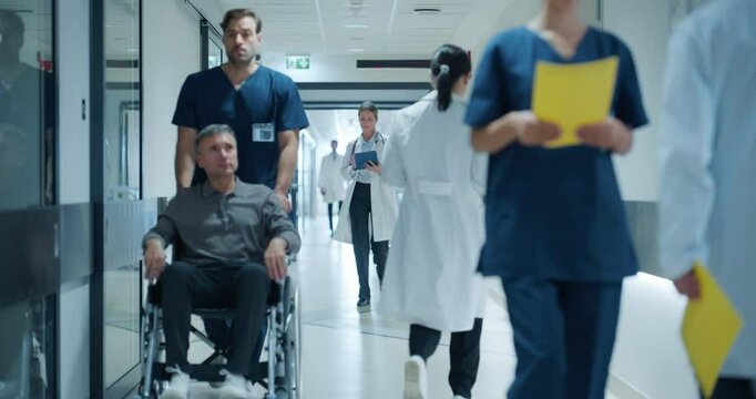 Diverse Medical Staff Walking Down a Hospital Hallway, Each Headed Towards Different Departments. Caucasian Female Doctor Discussing Treatment Plans, Reviewing Patient Charts on a Tablet