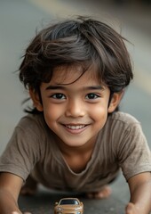 Obraz premium A young boy is smiling and holding a toy car