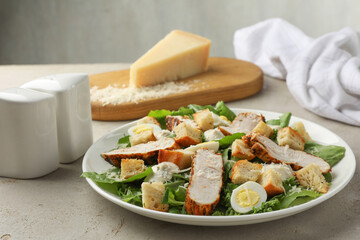 Tasty Caesar salad with chicken on light grey table