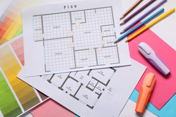 Designer's workplace with house plans, color palettes and stationery on table, top view